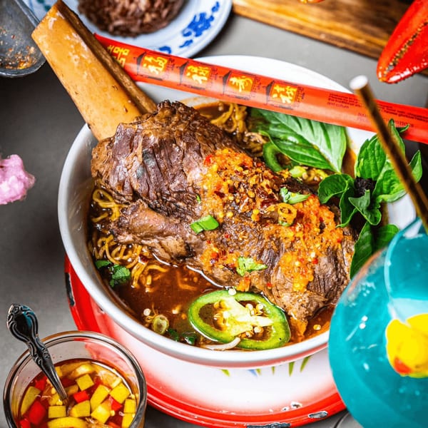 Thai short rib noodle soup with basil, chili, and jalapeños, served with a side of sauce.