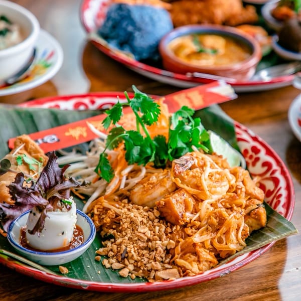A vibrant plate of Farmhouse Kitchen Thai's Pad Thai with shrimp, tofu, peanuts, and cilantro.